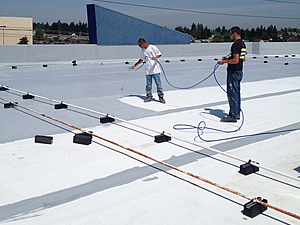 Applying elastomeric coating over existing roof coating on Best Buy roof, Tacoma